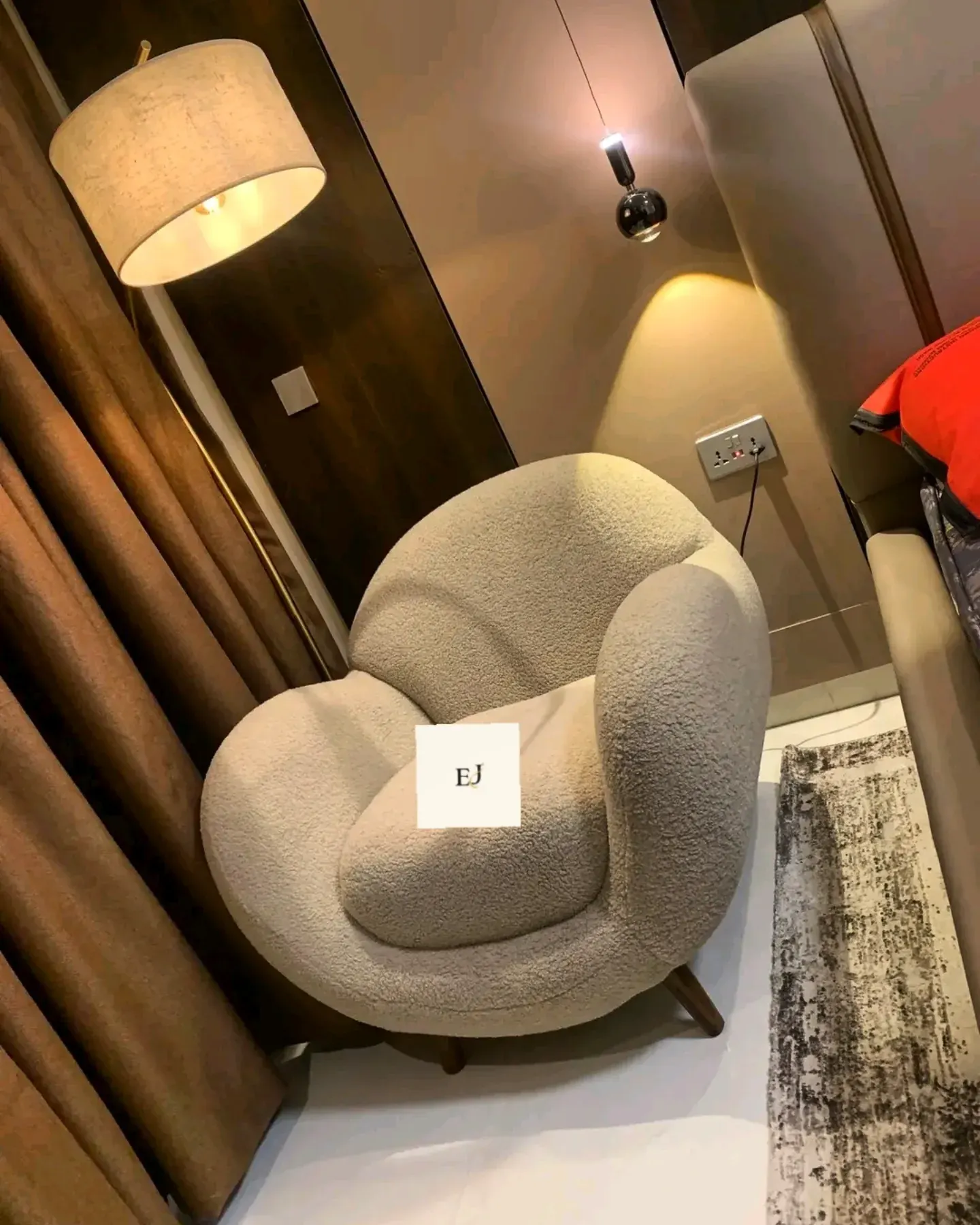 A cream boucle barrel armchair in a finished room beside a lamp